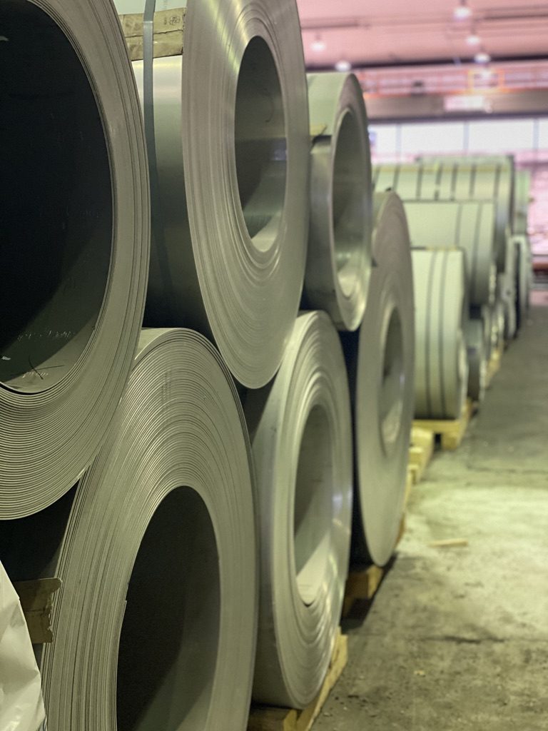 Reihe gelagerter Edelstahl-Coils in der Lagerhalle