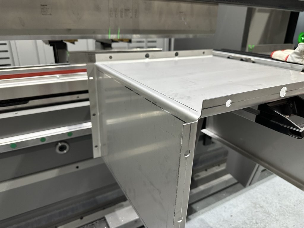 Fertig gekantetes Edelstahlbauteil mit Bohrungen an der Abkantpresse